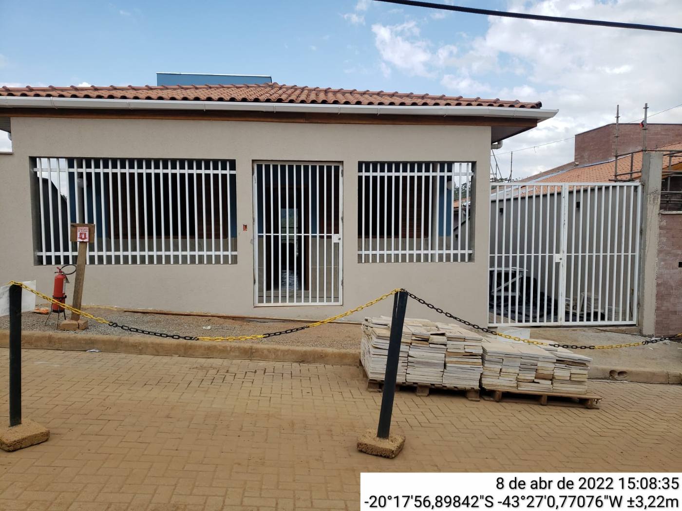 Grades de ferro em janelas e portão social pintados de branco